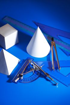 Geometry concept. Set of various paper shapes near rulers and divider