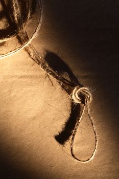 Twine with loop on old brown paper with shadow