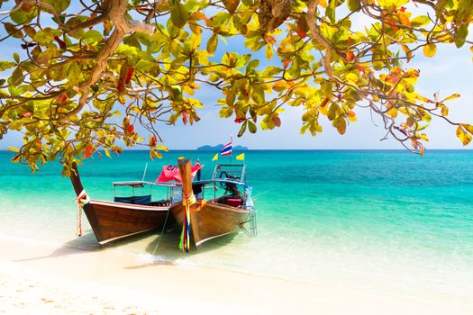 Traditional wooden long tail boats on a picture perfect tropical beach near Phuket, Thailand, Asia.