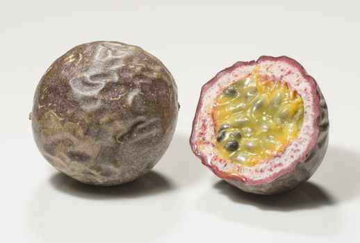 Passion Fruit Cross Section Close up. One uncut and whone sliced in half.