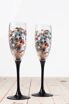 Champaign glasses with confetti, isolated on white background