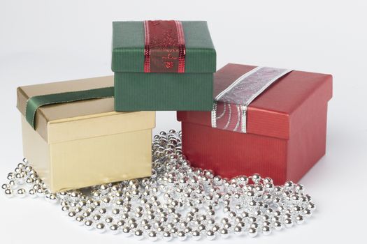 Three presents with ribbons, red, green and gold, isolated on white background