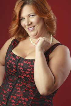 female plus size fashion model holding her pearl necklace
