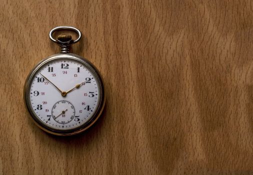 Vintage pocket watch on wooden surface