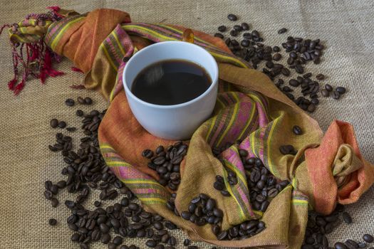 A Cup of coffee with cinnamon and coffee beans