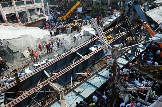 INDIA, Kolkata: Indian rescue workers and volunteers try to free people trapped under the wreckage of a collapsed flyover bridge in Kolkata on March 31, 2016. At least 14 people were killed and dozens more injured when a flyover collapsed in a busy Indian city on March 31, an official said, as emergency workers battled to rescue people trapped under the rubble.