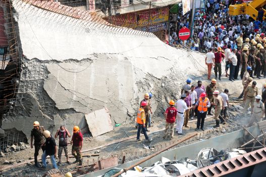 INDIA, Kolkata: Indian rescue workers and volunteers try to free people trapped under the wreckage of a collapsed flyover bridge in Kolkata on March 31, 2016. At least 14 people were killed and dozens more injured when a flyover collapsed in a busy Indian city on March 31, an official said, as emergency workers battled to rescue people trapped under the rubble.