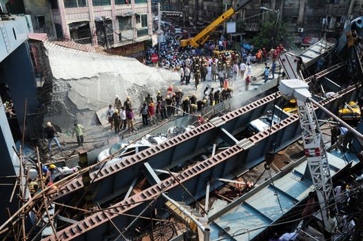 INDIA, Kolkata: Indian rescue workers and volunteers try to free people trapped under the wreckage of a collapsed flyover bridge in Kolkata on March 31, 2016. At least 14 people were killed and dozens more injured when a flyover collapsed in a busy Indian city on March 31, an official said, as emergency workers battled to rescue people trapped under the rubble.