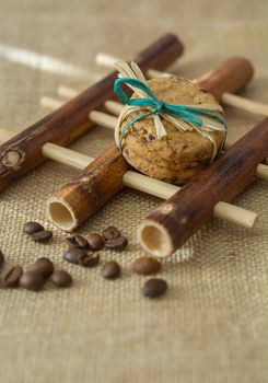 Homemade cookies and coffee beans on bamboo pad, gray background