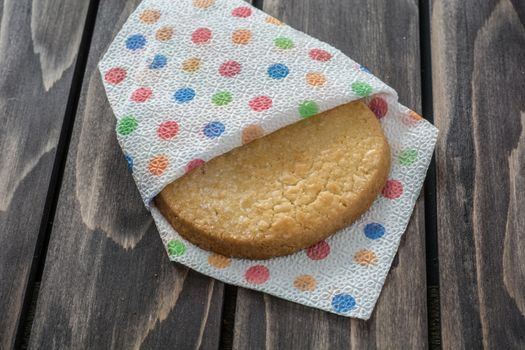 Danish cookie in napkin on wooden table.Closeup