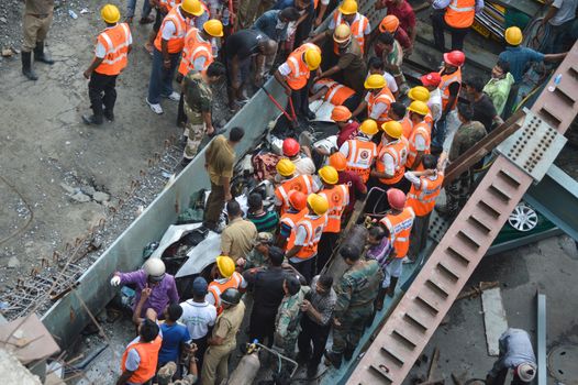 INDIA, Kolkata: Indian soldiers, rescue workers and volunteers try to free people trapped under the wreckage of a collapsed flyover bridge in Kolkata on March 31, 2016. At least 14 people were killed and dozens more injured when a flyover collapsed in a busy Indian city on March 31, an official said, as emergency workers battled to rescue people trapped under the rubble.