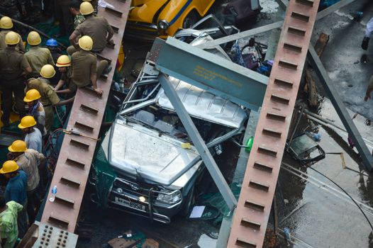 INDIA, Kolkata: Indian soldiers, rescue workers and volunteers try to free people trapped under the wreckage of a collapsed flyover bridge in Kolkata on March 31, 2016. At least 14 people were killed and dozens more injured when a flyover collapsed in a busy Indian city on March 31, an official said, as emergency workers battled to rescue people trapped under the rubble.