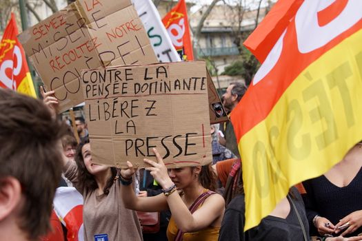 FRANCE, Nîmes: A protester holds a sign reading 'Against the dominant thinking: free the press' as thousands of protesters march during a demonstration against the French government's planned labour law reforms on March 31, 2016 in Nîmes. France faced fresh protests over labour reforms just a day after the beleaguered government of President Francois Hollande was forced into an embarrassing U-turn over constitutional changes.