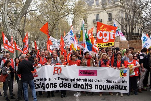 FRANCE, Nîmes: Protesters march holding flags and banners as thousands of protesters march during a demonstration against the French government's planned labour law reforms on March 31, 2016 in Nîmes. France faced fresh protests over labour reforms just a day after the beleaguered government of President Francois Hollande was forced into an embarrassing U-turn over constitutional changes.