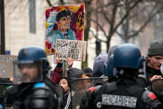 FRANCE, Paris: A student holds a placard which reads No to police violence as French riot police officers stand in line as thousands demonstrate against the French government's planned labour law reforms on March 31, 2016 in Paris. France faced fresh protests over labour reforms just a day after the beleaguered government of President Francois Hollande was forced into an embarrassing U-turn over constitutional changes.