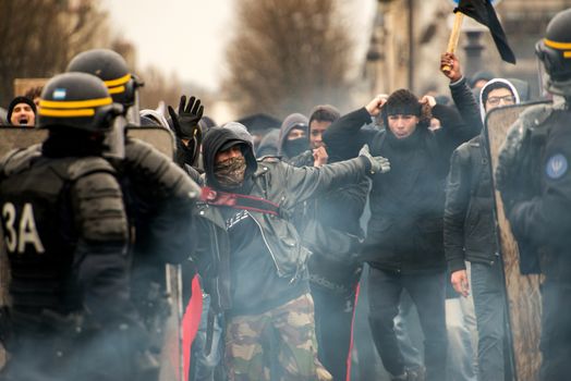 FRANCE, Paris: Protesters clash with French riot police officers stand in line as thousands demonstrate against the French government's planned labour law reforms on March 31, 2016 in Paris. France faced fresh protests over labour reforms just a day after the beleaguered government of President Francois Hollande was forced into an embarrassing U-turn over constitutional changes.