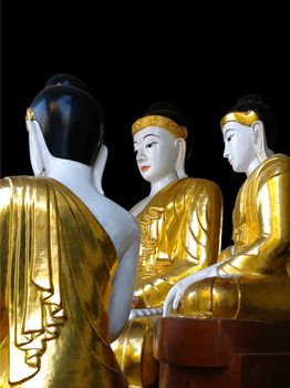 Gold and white Buddha statues at the Shwedagon Pagoda in Yangon, Myanmar (Black background)