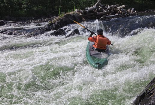 Kayaker in the  whitewater of a river Umba in Russia