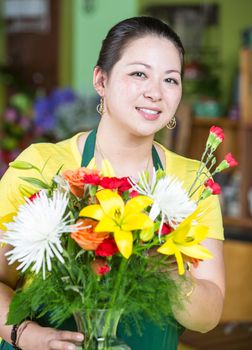 Beautiful young woman creating a floral arrangement