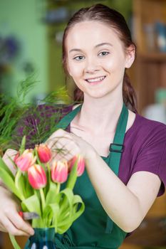 Smiling young woman creating a tulip arrangement