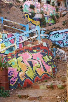 Colourfully decorated path leading up a hillside in the UNESCO World Heritage port city of Valparaiso, Chile.