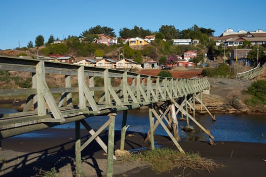 Wooden bridge over a river connecting the small fishing village of Curanipe in the Maule Region of Chile with the beach.