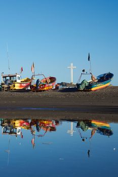 Colourful fishing boats reflected in a river in the small fishing town of Curanipe, Chile.