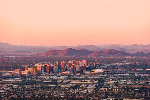 Phoenix Arizona with its downtown lit by the last rays of sun at the dusk.