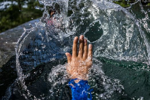 A shot of a person's hand pushing the water making a big splash.