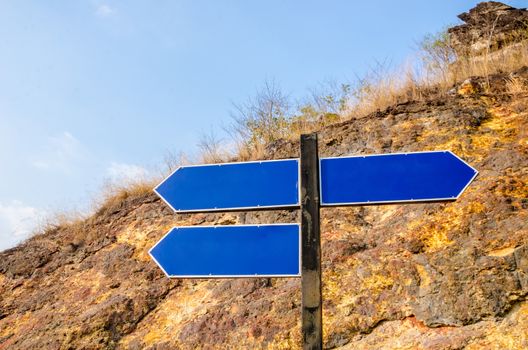 Good Better Best on blue sign road at cliff.