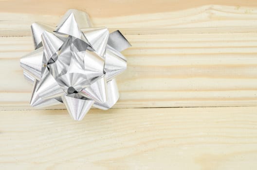 Silver ribbon with copy space on wooden background.
