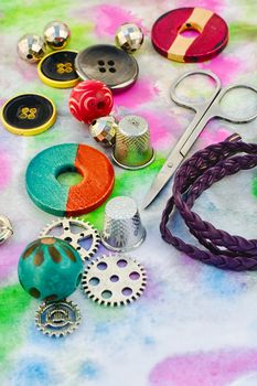 Beads and tools for needlework on bright colorful background
