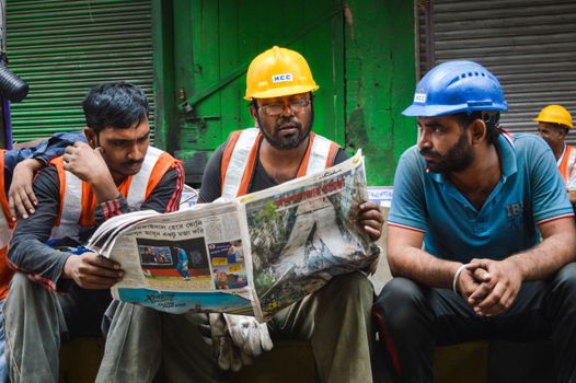 INDIA, Kolkata: Indian rescue workers read the newspaper, as rescue operation goes on in order to free people trapped under the wreckage of a collapsed flyover bridge in Kolkata on April 1, 2016. Emergency workers in India battled to rescue dozens of people still trapped after a flyover collapsed onto a busy street, killing at least 22 people and injuring over 100 more.