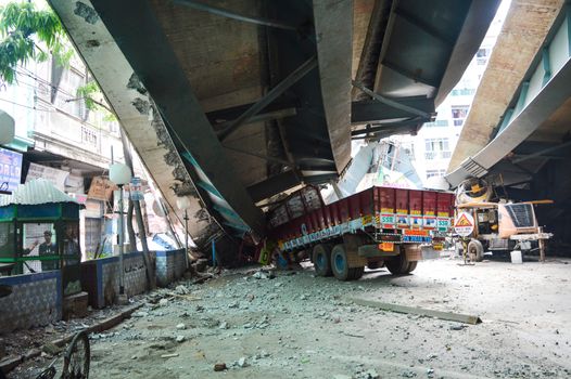 INDIA, Kolkata: A crushed truck is seen on site as Indian rescue workers clear away debris amid efforts to free people trapped under the wreckage of a collapsed flyover bridge in Kolkata on April 1, 2016. Emergency workers in India battled to rescue dozens of people still trapped after a flyover collapsed onto a busy street, killing at least 22 people and injuring over 100 more.