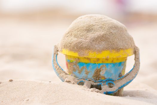 Childrens bucket with sand on the beach