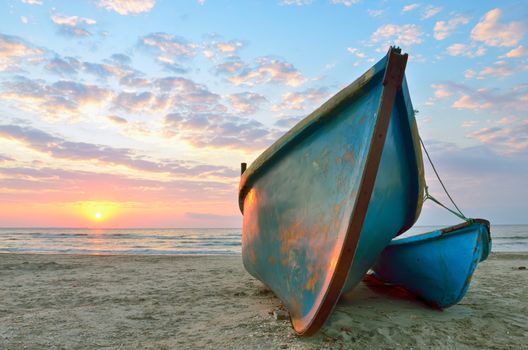 Beautiful sunrise over an two wooden fishing boats