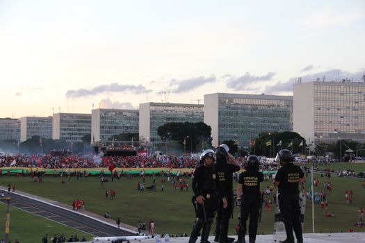 BRAZIL, Brasília : Police stand next to the Congress as unionists and Worker's Party (PT) supporters demonstrate in support of President Dilma Rousseff and former President Luiz Inacio Lula da Silva in Brasilia on March 31, 2016. Brazil's Supreme Court on Thursday removed a politically explosive case against former president Luiz Lula Inacio da Silva from a crusading corruption judge. Judges voted to put Lula's case under the jurisdiction of the Supreme Court and not federal Judge Sergio Moro. Lula is accused of money laundering and concealing property in connection with a huge probe led by Moro into state oil company Petrobras. 