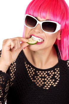 woman with pink hair eating raw vegetable