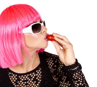 woman with pink hair eating raw vegetable