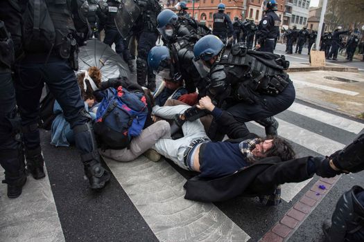 FRANCE, Toulouse:  French riot police officers arrest protesters during a demonstration against the French government's planned labour law reforms on March 31, 2016 in Toulouse, southern France. France faced fresh protests over labour reforms just a day after the beleaguered government of President Francois Hollande was forced into an embarrassing U-turn over constitutional changes. 