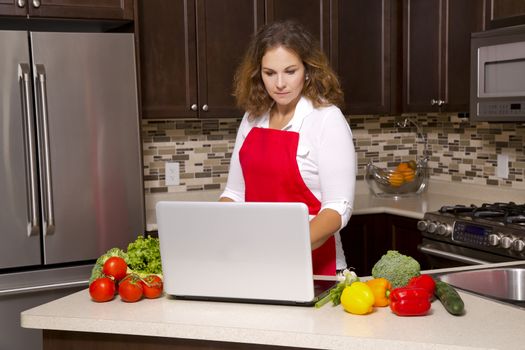 woman searching recipes online while cooking raw vegetables