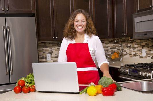 woman searching recipes online while cooking raw vegetables