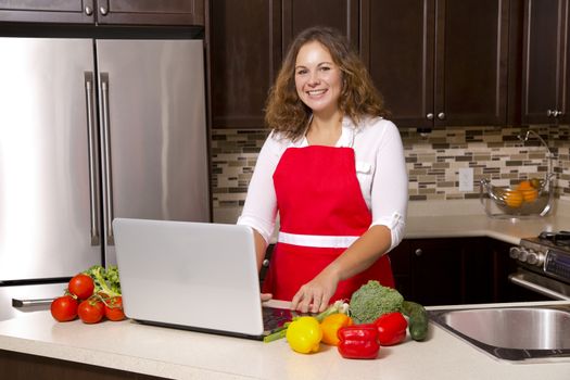 woman searching recipes online while cooking raw vegetables