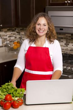 woman searching recipes online while cooking raw vegetables