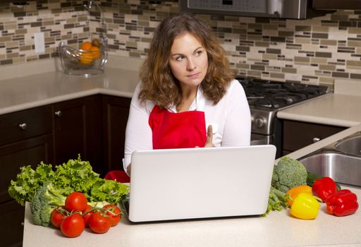 woman searching recipes online while cooking raw vegetables