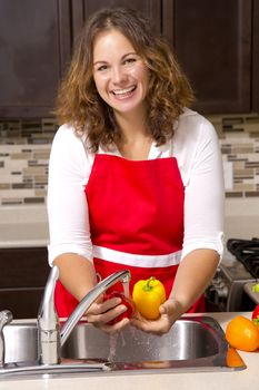 woman washing vegetables in the sink home kitchen