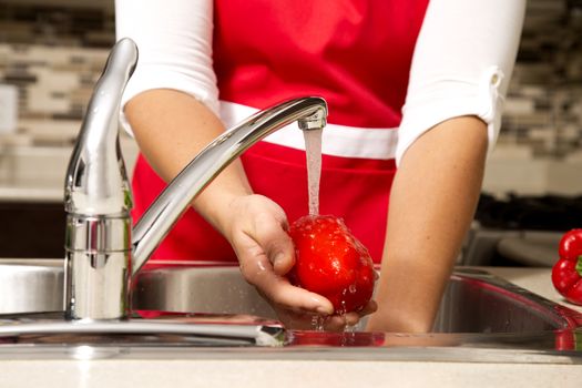 woman washing vegetables in the sink home kitchen