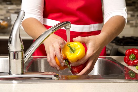 woman washing vegetables in the sink home kitchen