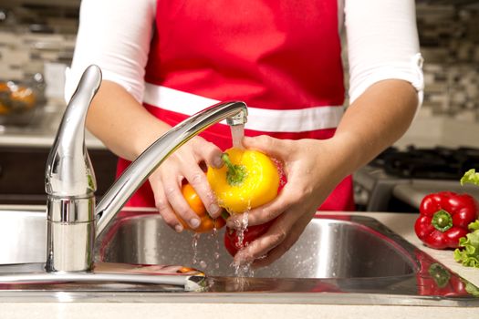 woman washing vegetables in the sink home kitchen