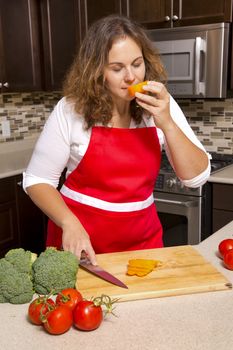 caucasian woman is smelling raw cut vegetables